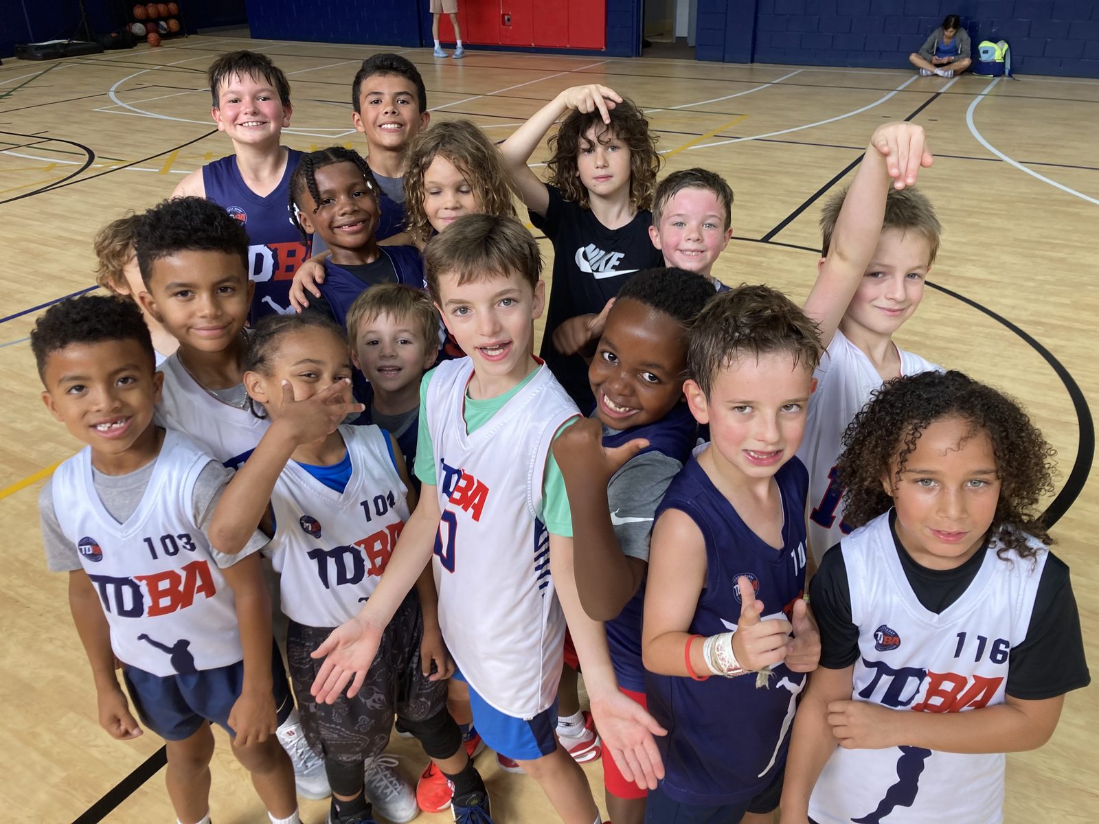 TDBA league players in their numbered TDBA jerseys celebrating on the court